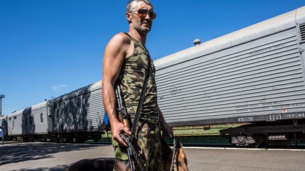 A pro-Russia rebel guards the train holding the bodies of MH17 victims.