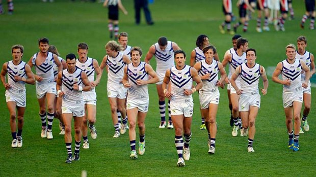 Fremantle players leave the ground at half-time, well behind on the scoreboard.