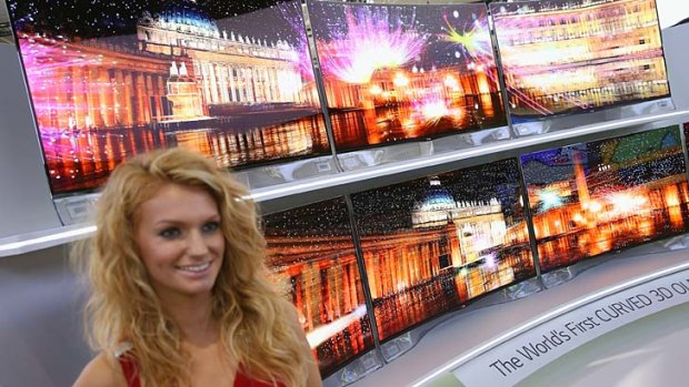 BERLIN, GERMANY - SEPTEMBER 05:  A hostess stands next to curved 3D OLED high-definition flat-screen televisions at the LG stand at the IFA 2013 consumer electronics trade fair on September 5, 2013 in Berlin, Germany. The 2013 IFA will be open to the public from September 6-11.  (Photo by Sean Gallup/Getty Images)