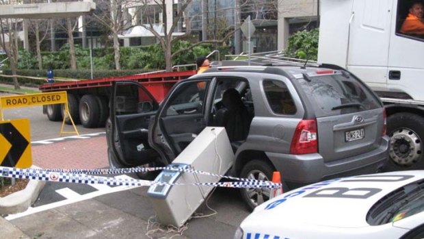 An ATM hangs out of the side of a car after an alleged robbery attempt at a brothel in Burwood.
