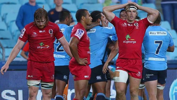 Dejected Reds players let another Waratahs' try sink in.