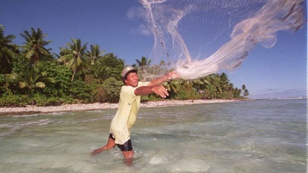 A fisherman casts his net on the shores of Majuro, Marshall Islands. Sea level rises likely to result from global warming would devastate the island nation.