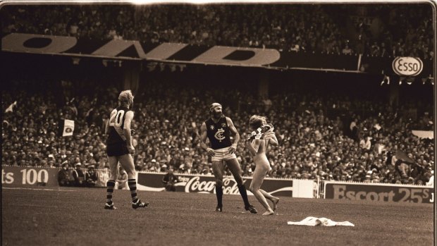 Streaker Helen D'Amico runs up to Carlton player Bruce Doull during the 1982 AFL grand final.