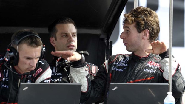 Will Power, right,  talks to his pit crew after being forced out of the IndyCar race in Toronto.