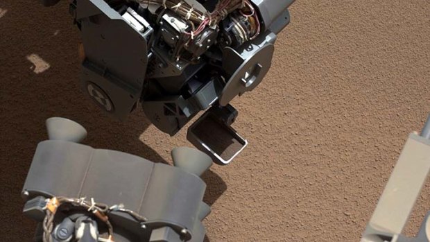 Curious ... NASA's Mars rover shows a scoop full of sand and dust lifted by the rover's first use of the scoop on its robotic arm.