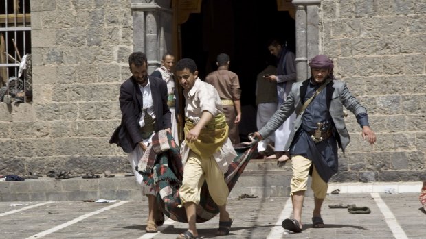 Yemenis carry the body of a man killed in the bombing out of the mosque in Sanaa.