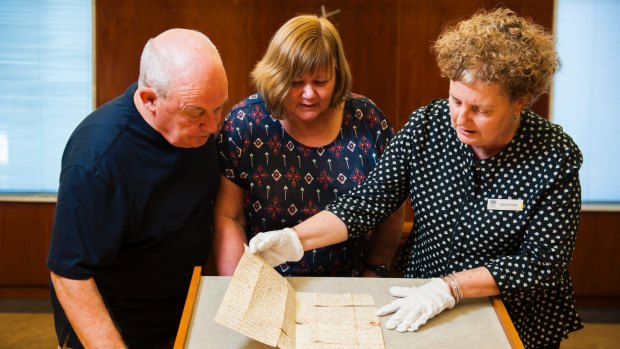 A letter written by William Charleson from Van Diemen's Land on 25 March, 1824, to his mother in Caithness, Scotland donated to the National Library of Australia.
Left to right: researcher Keith Blackburn, family donor of letter Claire Henson and (in gloves) curator Kylie Scroope.
