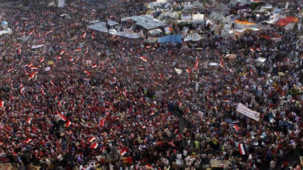 Protesters shout slogans and wave flags in Tahrir Square in Cairo, Egypt.