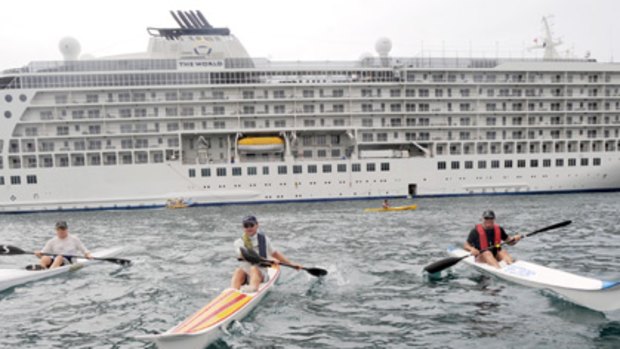 Round the World ...  Peter Fane, Ashley Phillips and Ken Bellette  paddle their kayaks near the cruise ship yesterday.