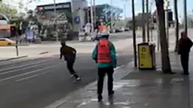 Spotting a stationary oBike on the other side of Swanston Street, the man rushes across the road to retrieve it.