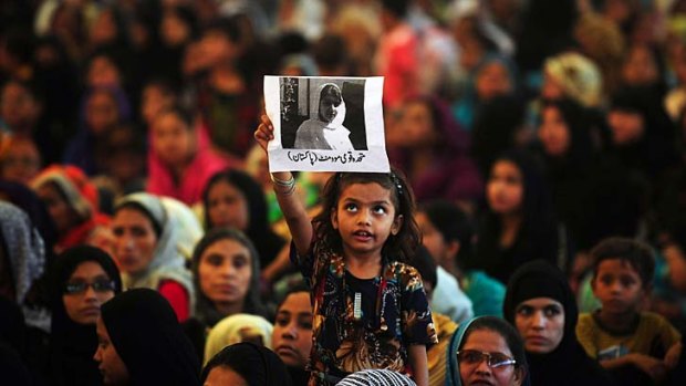 Held high ... a young supporter holds up a photo of Malala Yousafzai.