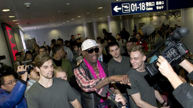 Former NBA basketball player Dennis Rodman gestures to the media as he arrives at the departure hall of Beijing International Capital Airport on Monday.