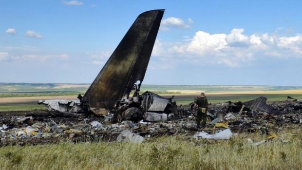 Pro-Russian separatists look through the debris of the plane that was taken down.