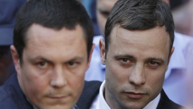 Oscar Pistorius, right, accompanied by a relative leaves the high court in Pretoria.