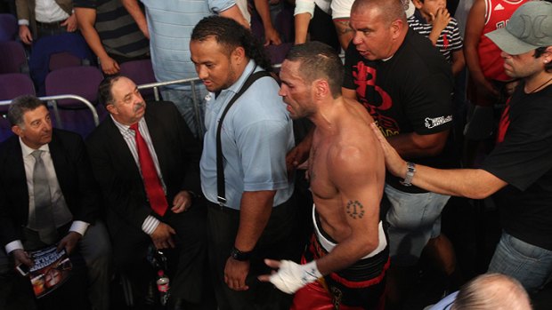 Down and out of there ... An unusually silent Anthony Mundine leaves the ring after his defeat.