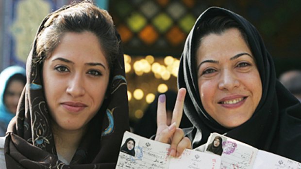 Iranian women show the ink on their fingers and their identification after voting in Tehran yesterday. Women have become a major force in the campaign.