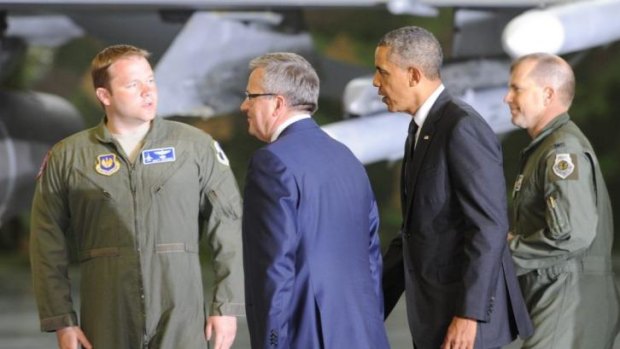 US President Barack Obama and Polish President Bronislaw Komorowski, second left, accompanied by US Air Force pilots walk for a meeting with soldiers at the military airport in Warsaw.