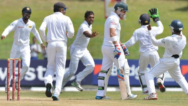 Sri Lankan bowler Dilruwan Perera (third from left) and teammates celebrate the dismissal of South Africa's Dean Elgar on the second day of the second Test in Colombo on Friday.