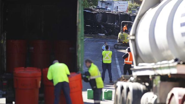 The charred wreckage of the petrol tanker lies on its side on Mona Vale Road.