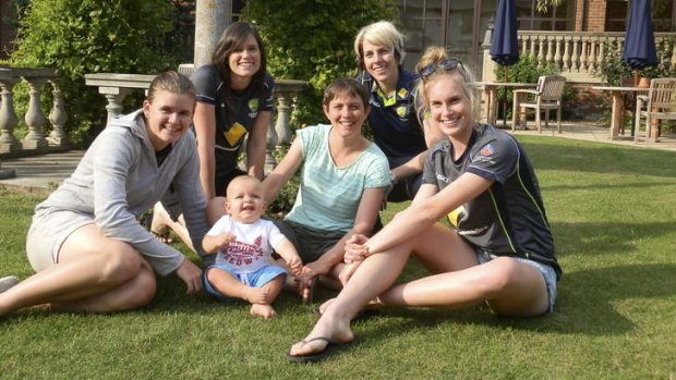 Holding the baby: Australia's Ashes stars enjoy some sun. From left, Jess Jonassen, Gemma Triscari, Sam and Sarah Elliott, Elyse Villani and Holly Ferling.