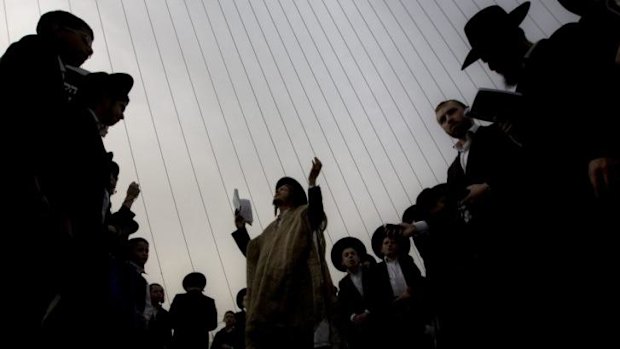 Ultra-Orthodox men pray at the rally.