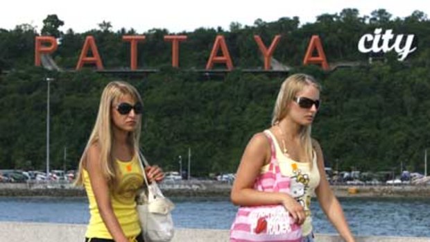 Tourists walk along a pier in Pattaya.