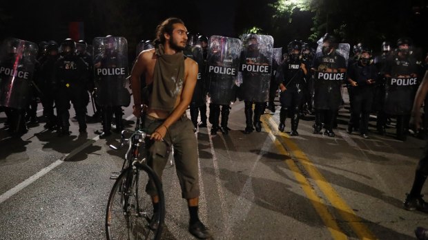 Police line up as protesters gather on Friday night.