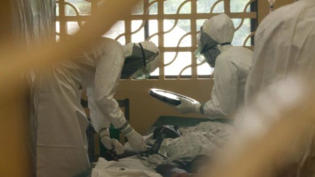 Dr. Kent Brantly (L) is shown wearing personal protective equipment as he cares for Ebola patients in Monrovia, Liberia.  Brantly has now tested positive for disease.