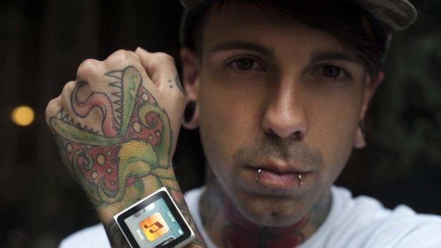 Tattoo artist Dave Hurban displays an iPod Nano which he has attached to his wrist through magnetic piercings.