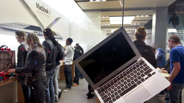 Shoppers look at Apple products as a MacBook Air laptop computer sits on display at an Apple store in San Francisco, California.
