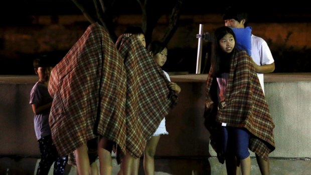 Children are covered with blankets as they are evacuated in front of a shelter near the demilitarised zone separating the two Koreas in Yeoncheon, South Korea, on Thursday.