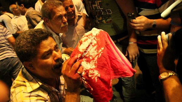 Egyptian Coptic Christians hold up a blood streaked cloth after a clash with soldiers and anti-riot police during a protest in Cairo.