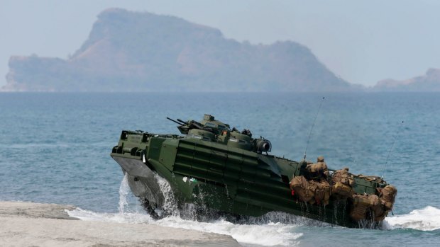 A US Navy amphibious assault vehicle with Philippine and US troops on board storms the beach at a combined assault exercise opposite one of the disputed South China Sea islets.