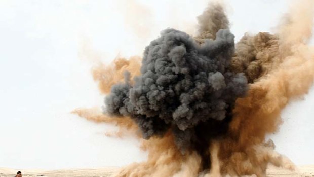 "If Gaddafi wins, we are all dead anyway" ... a rebel protects his ears as a bomb dropped by a Libyan air force jet explodes in the desert near Brega.