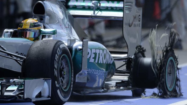 Mercedes Formula One driver Lewis Hamilton of Britain enters Silverstone's pitlane with an exploded tyre.