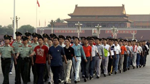 Show of force...Chinese paramilitary police in uniform and plain clothes marched past the public after a flag-raising ceremony in Tiananmen Square yesterday.