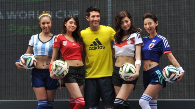Target markets ... Taiwanese football player Xavier Chen (centre) poses with models holding Brazuca balls.