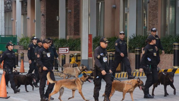 Bomb sniffing dogs walk outside a hotel at the Resorts World Manila complex.
