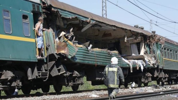 Crushing blow ... A passenger and a firefighter examine damage to a carriage of a passenger train after it collided with a freight train near Moscow. At least five people were killed and 45 injured.