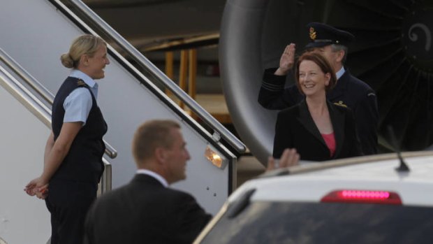 Prime Minister Julia Gillard is all smiles as she returns to Canberra from India.