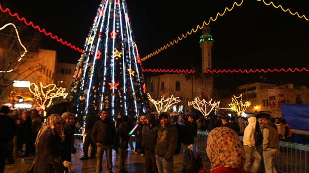 A Palestinian Muslim woman takes pictures in Manger Square, the central plaza next to the Church of the Nativity.