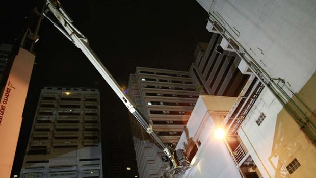 Firefighters in cranes search for people stranded on upper floors after a fire in a hotel.