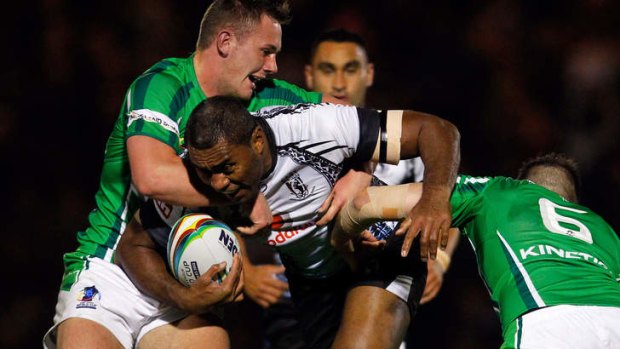Petero Civoniceva of Fiji is tackled by Ireland's Ben Currie (L) and James Mendeika.