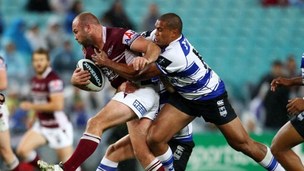 Glenn Stewart of the Sea Eagles is tackled by the Bulldogs' Frank Pritchard.