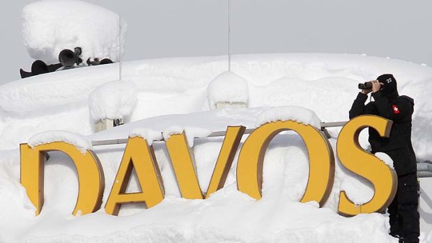 A member of Swiss special police forces observes from the roof of a hotel covered in snow in Davos.