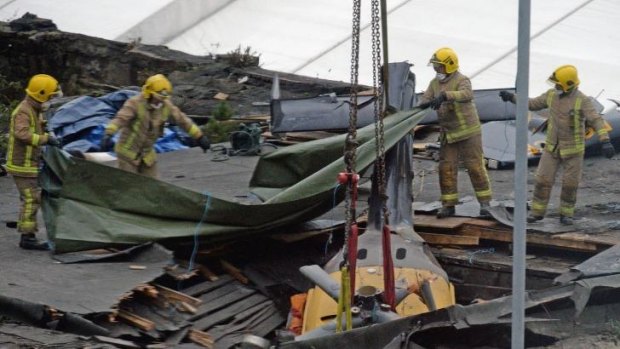 Rescuers lift the police helicopter wreckage from the roof of The Clutha pub in Glasgow.
