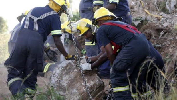 Rescue workers move a rock removed from the mine shaft.