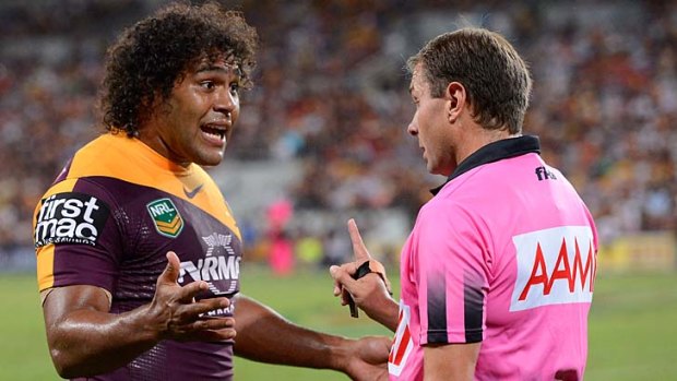 Touching: Sam Thaiday grabs the jersey of referee Adam Devcich.