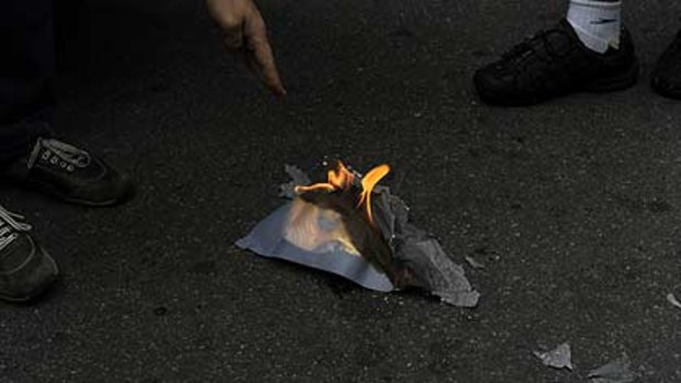 Protesters burn a photograph of Hosni Mubarak in Sao Paolo in Brazil.