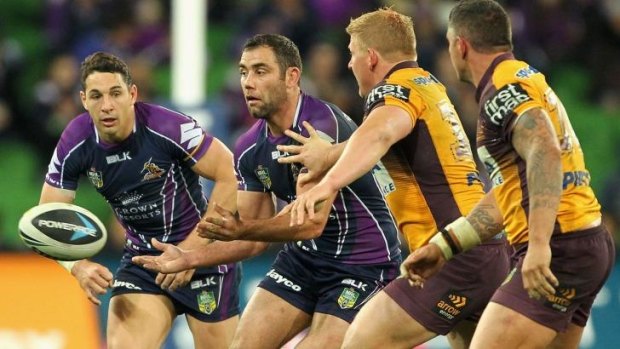 Cameron Smith (second from left) offloads during the round 26 game against the Brisbane Broncos.
